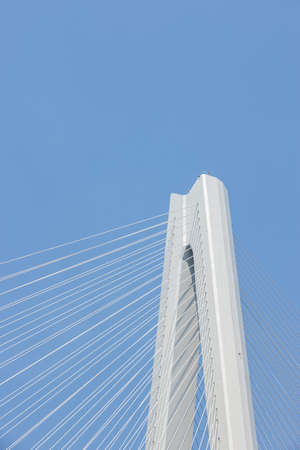 cable-stayed bridge close-up, main tower and cable against a blue skyの写真素材