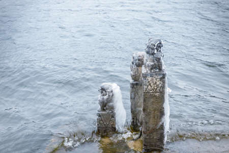 stone lions standing by the lake, small scene of Lushan mountain in winterの写真素材