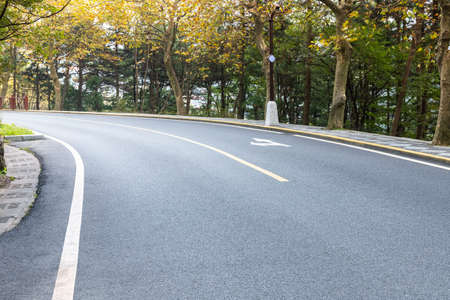 curved asphalt road, mountain road in autumn forestの写真素材