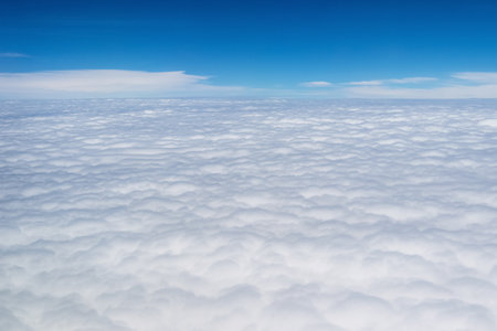 above the thick clouds, sky scene outside the porthole of an airplaneの写真素材
