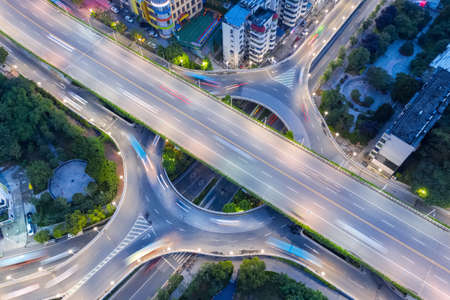 aerial view of road interchange in nightfall, small circular urban overpassの写真素材