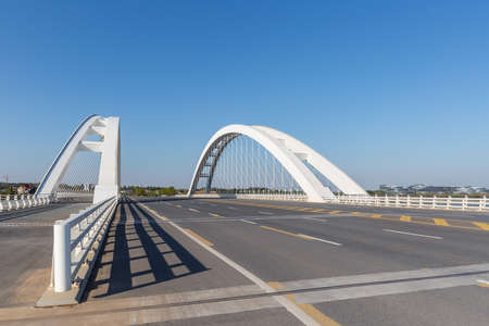 modern through bridge against a blue sky, rigid tied arch through bridgeの写真素材