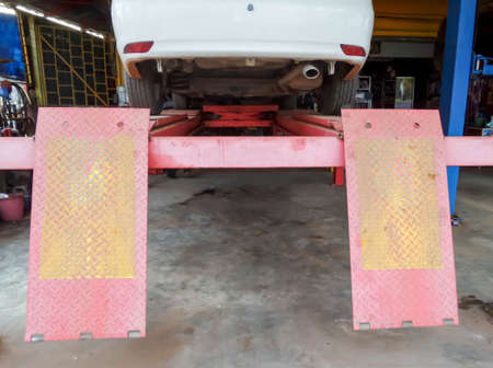 The car was repaired on a lift in the garage.の写真素材