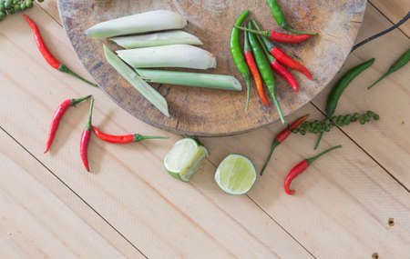 Tom Yum spices and chopping board on a wooden floor.