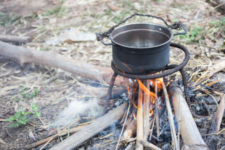 Pot boiling water in countryside.の写真素材