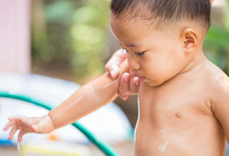 Child are bathing outside the house.の写真素材