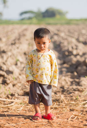 A boy standing on a country road.の写真素材