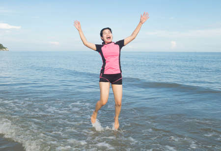 Woman jumping on the beach.の写真素材