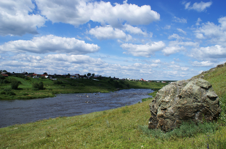 The Ural river under the blue sky with white cloudsの写真素材