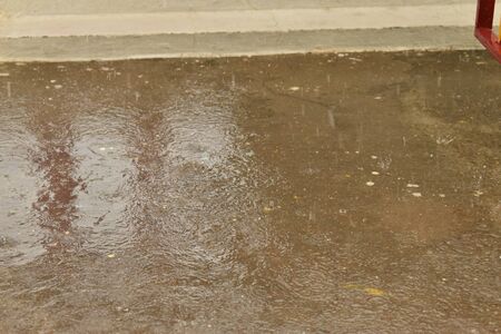 rain drops on the surface of water in the floor with graduated shade of black shadow and reflection...