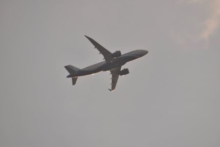 an air plain taking off in the clouds during sunset in india.