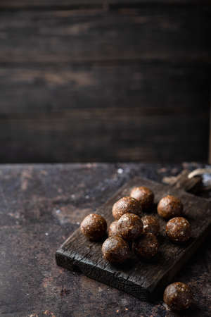 homemade chocolate sweets from nuts, dried fruits and cocoa on a dark background. Place for text