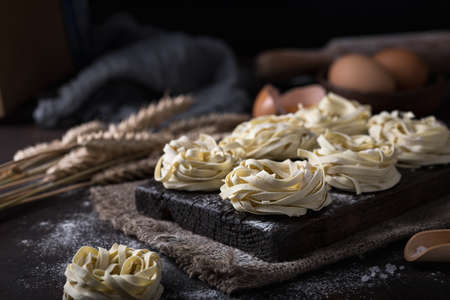 Raw uncooked homemade italian pasta tagliatelle on a darkの写真素材