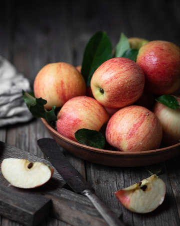 Red apples in a ceramic plate on a dark woodenの写真素材