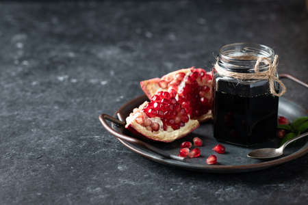 pomegranate sauce on a metal tray on a dark background, place for text.の写真素材