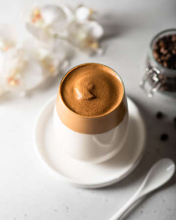 coffee dalgona in a glass on a light background, fashion korean trend.
