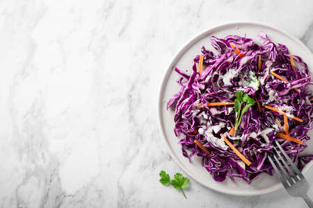 Red cabbage coleslaw with carrot on a light background, top view, place for text. Healthy food concept.の写真素材