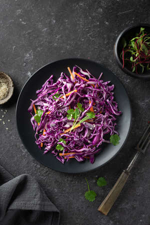 Red cabbage coleslaw with carrot on a dark background, top view. Healthy food concept.の写真素材