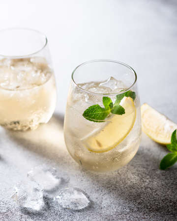 cold lemonade with ice, mint and lemon in a glass on a light background.の写真素材