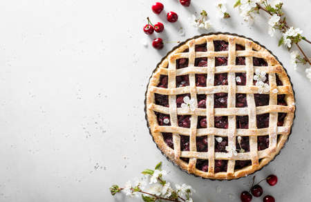 whole homemade cherry pie on a light background, place for your text