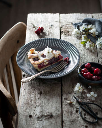 a piece of cherry pie on a rustic old wooden table.の写真素材