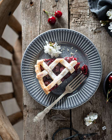 broken piece of cherry pie on a rustic old wooden table.の写真素材