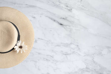 hat with flower on a marble background, top view, copy space. The concept of relaxation, vacation and summerの写真素材