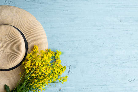 Hat and wildflowers on blueの写真素材