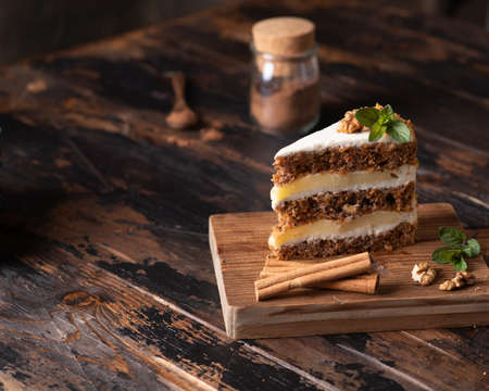 piece of carrot cake on a brown wooden background. Rustic style, place for textの写真素材