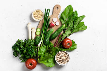 Healthy vegan food concept. Fresh vegetables, herbs and nuts on a light background, top viewの写真素材