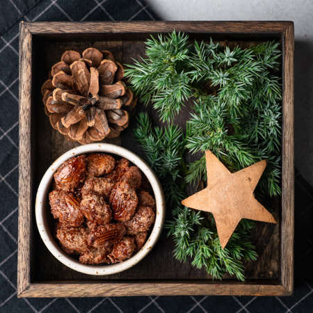 Christmas candied almonds in a wooden box on a light backgroundの写真素材