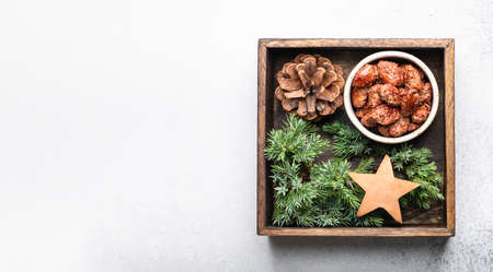 Christmas cinnamon roasted nuts in a wooden box on a light backgroundの写真素材