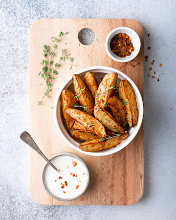 baked potato wedges with sauce on a light background, top viewの写真素材