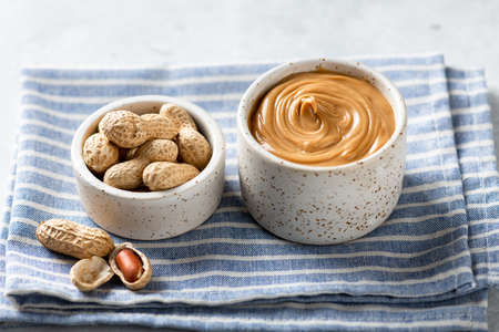 peanut butter in a ceramic bowl on a light background