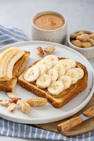 Peanut butter banana sandwich in a white plate on gray