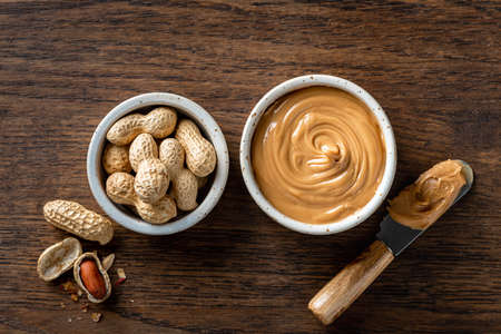 Peanut butter in a ceramic bowl on woodenの写真素材
