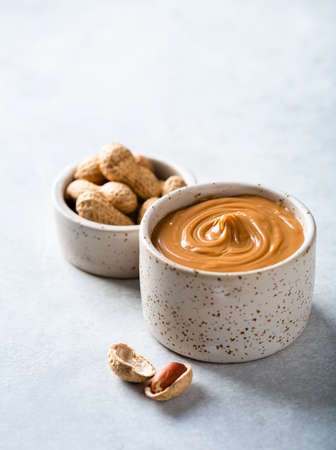 peanut butter in a ceramic bowl on a light background