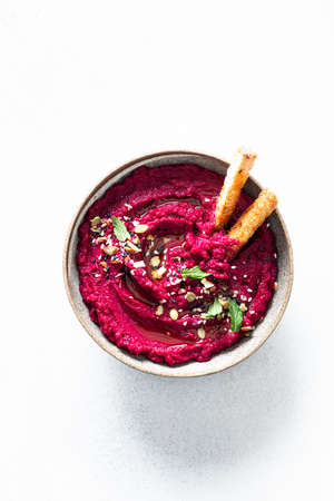 beet hummus in a ceramic bowl on a white background, top view, copy spaceの写真素材