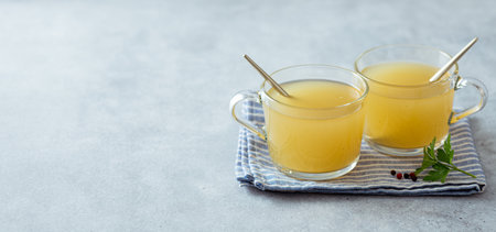 bone broth in a glass cup on a light background, selective focusの写真素材