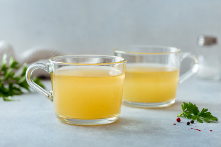 bone broth in a glass cup on a light background, selective focusの写真素材