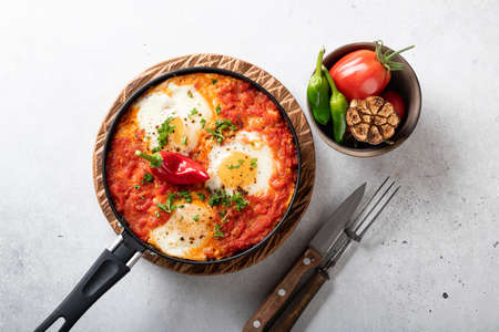 Shakshuka, fried eggs with vegetables in a frying pan, traditional israeli cuisine, top viewの写真素材