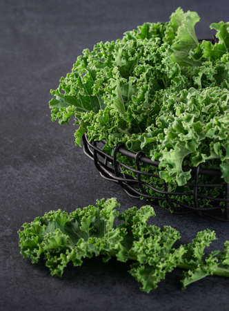 kale leaves in a basket on a dark backgroundの写真素材
