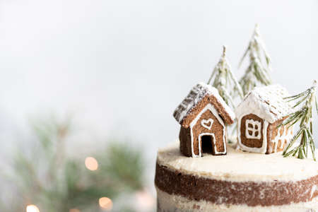 Christmas cake with gingerbread houses. New year card, place for text, selective focus
