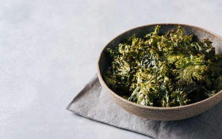 Kale chips in a ceramic bowl, copy space, selective focus