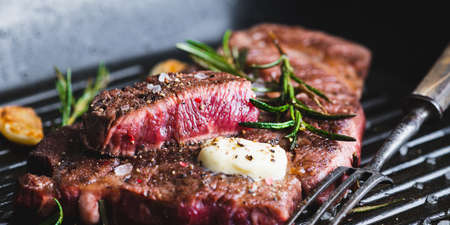 beef steak with rosemary, black pepper, sea salt and butter on a grill pan, selective focus, bannerの写真素材