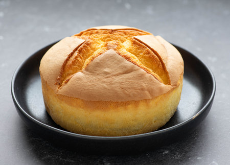 Japanese cheesecake on a black plate, selective focus