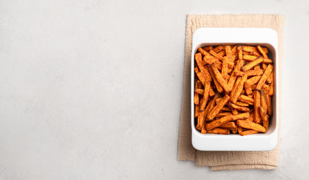 Sweet potato wedges in white baking dish on a gray background, top view, copy spaceの写真素材