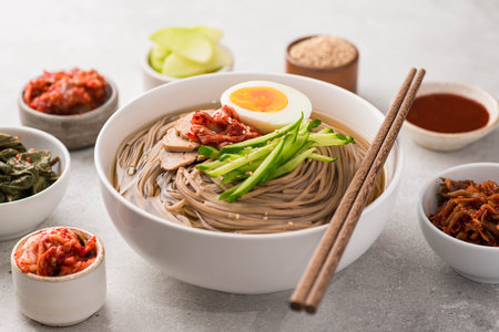 Korean cold noodles, Naengmyeon with banchan, selective focusの写真素材