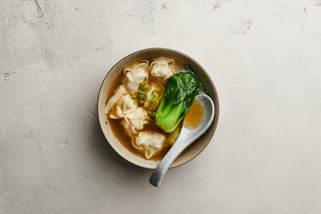 Chinese wonton soup on light concrete background, top viewの写真素材