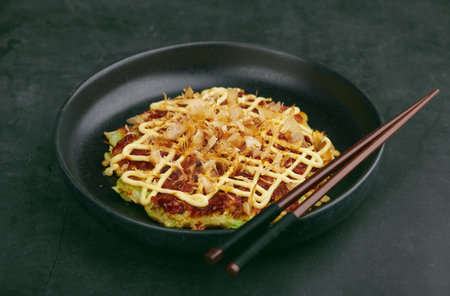 Japanese Okonomiyaki pancakes on black plate, selective focusの写真素材